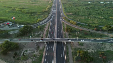 Aerial-view-of-a-highway-with-car-traffic-on-a-bridge-with-vegetation-around