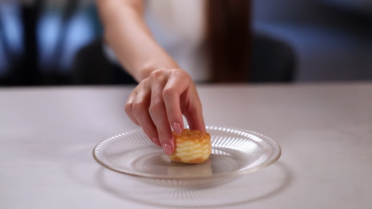 A hand placing a mini dessert on a glass plate