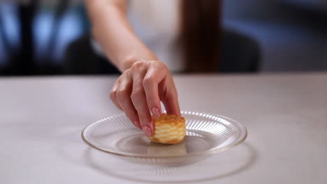 a hand placing a mini dessert on a glass plate
