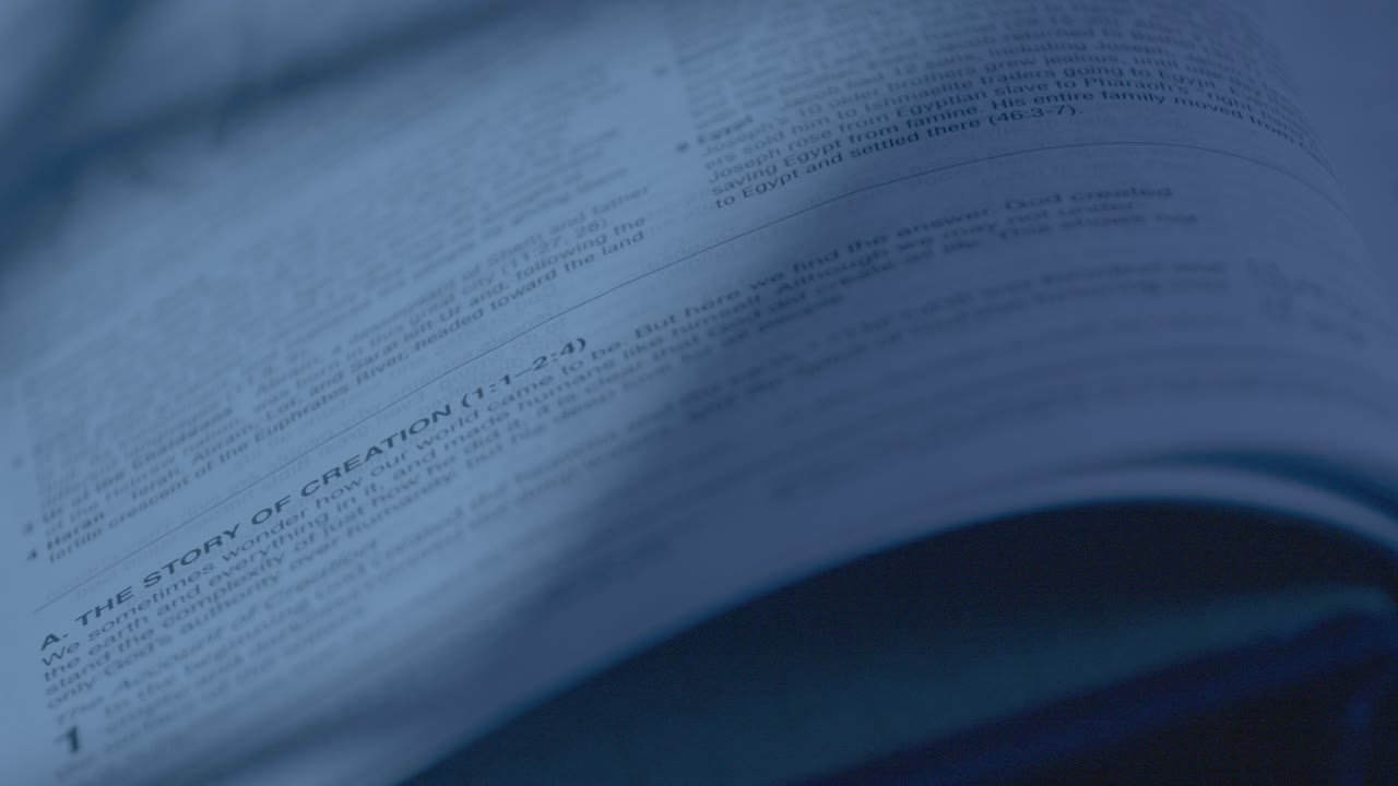 Detailed close-up shot of a Bible page under soft, ambient lighting. The text is blurred slightly, creating a serene and contemplative mood. Perfect for religious themes