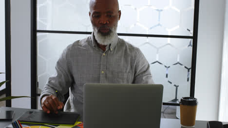 Businessman-having-coffee-while-using-graphic-tablet-on-desk-4k