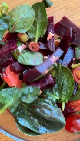 tossing a fresh beet and spinach salad