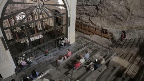 group of faithful praying in the chapel of the sanctuary of the holy cave, where the virgin of the cave is located, in altura, castellón