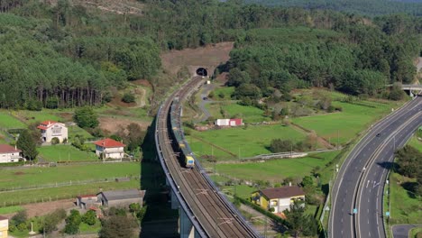 aerial view of a train on a bridge crossing a highway