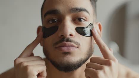 man applying eye patches