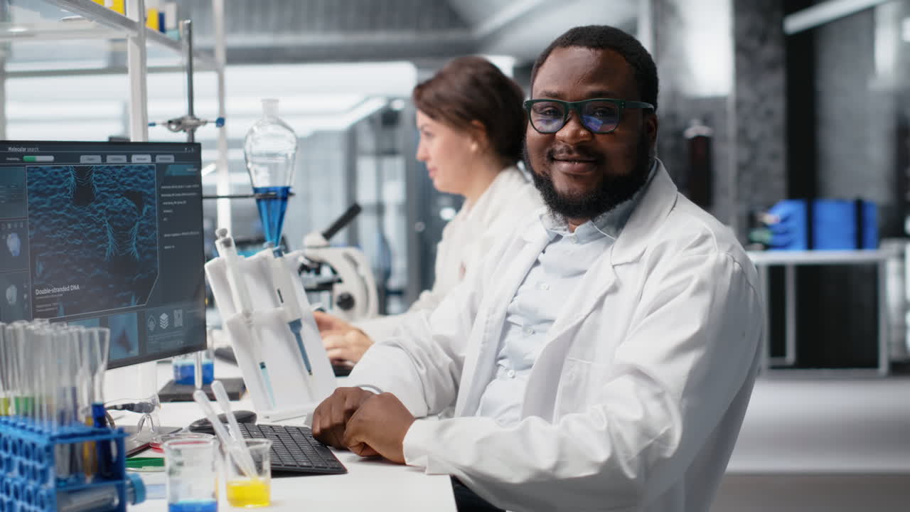 Vertical video Portrait of happy scientist using computer program for DNA data analysis