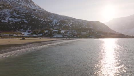 drone flight along beach in grotfjord, reflection of sunset