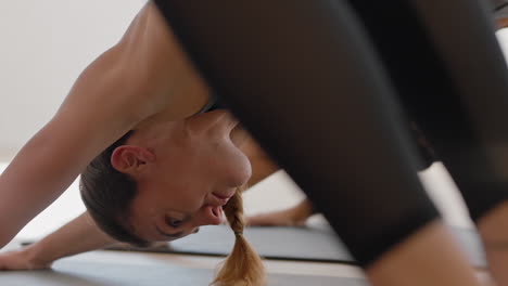 mujer de yoga caucásica saludable practicando meditación de pose guerrera disfrutando de ejercitar el cuerpo flexible en el gimnasio