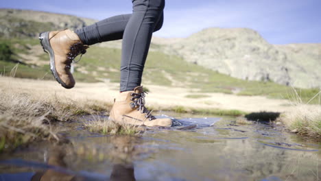 madrid penalara park españa, cámara lenta de trekker usando zapatos impermeables cruzando el lecho del río en un sendero de aventura de montaña