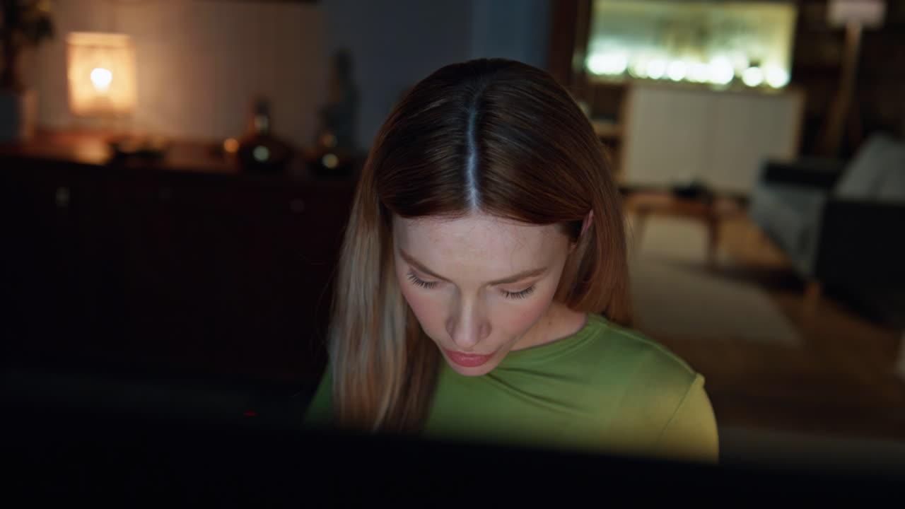 Lady entrepreneur working late evening looking computer in living room close up.