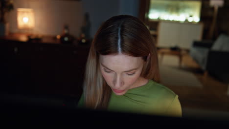 Lady entrepreneur working late evening looking computer in living room close up.