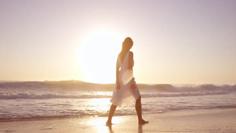 Schöne-Frau-In-Weißem-Kleid,-Die-Bei-Sonnenuntergang-Am-Strand-Spaziert,-In-Zeitlupe,-Roter-Drache