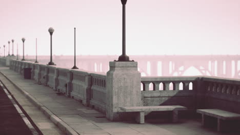 a view of a stone bridge with lamp posts and benches