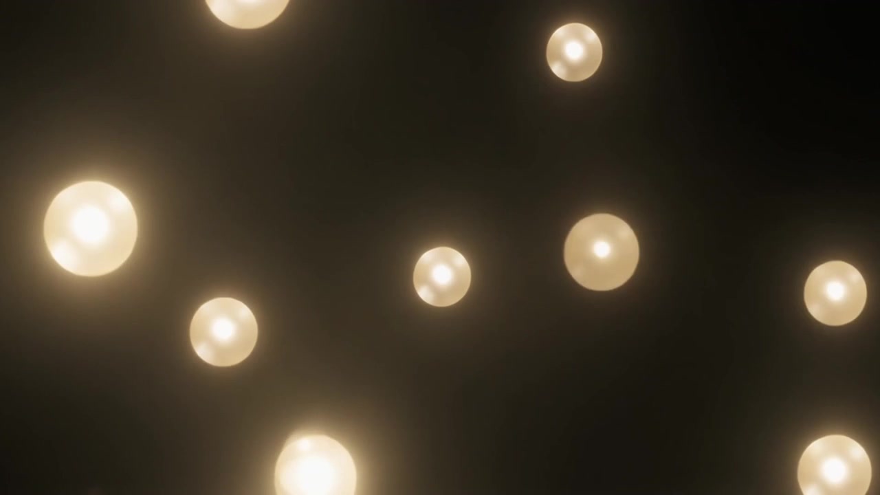 Schwebende leuchtende goldene Kugeln auf dunklem Hintergrund