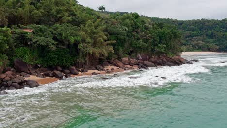 Drone-low-flight-over-sea-water-near-forest