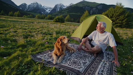 senior man camping with dog in mountains