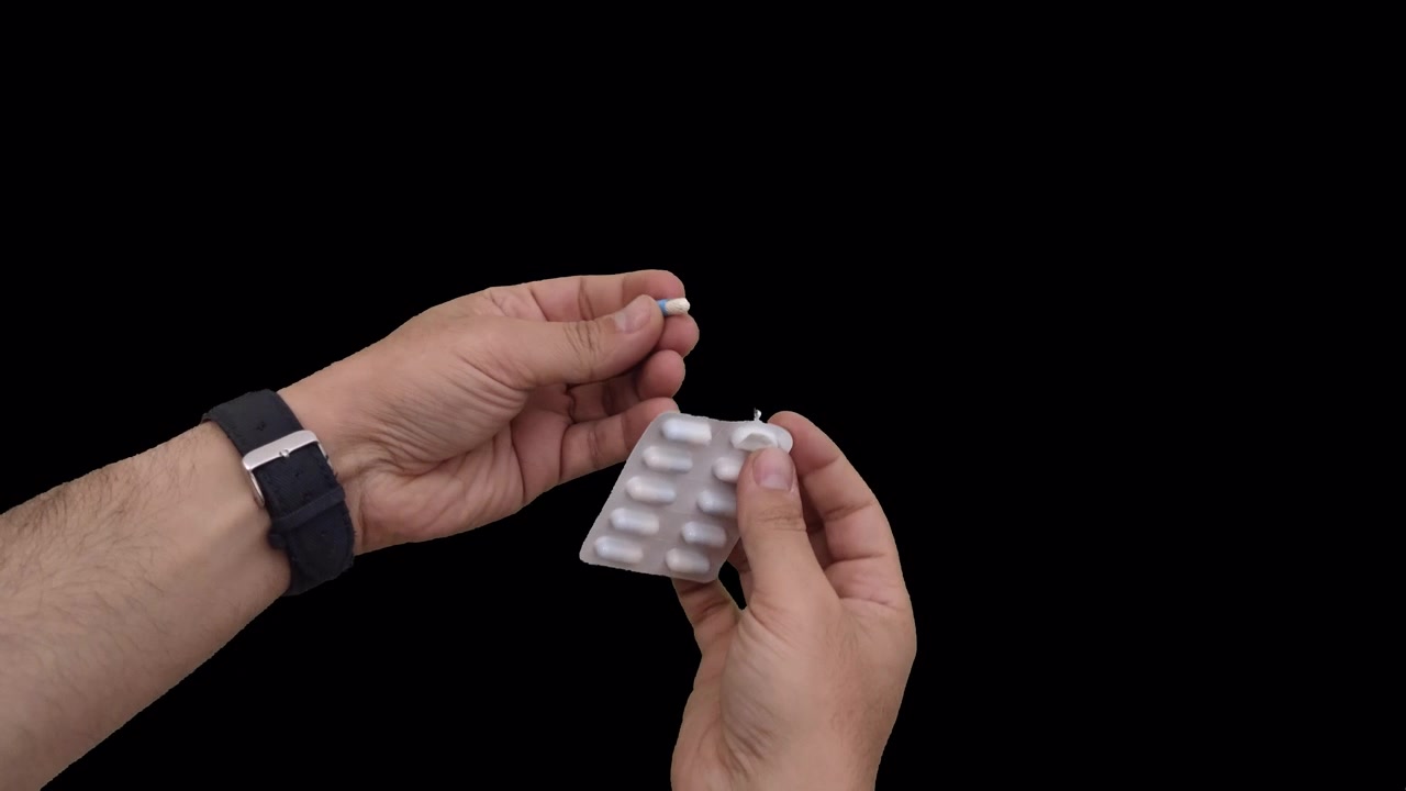 Person Pushing a Pill Out of a Blister Pack
