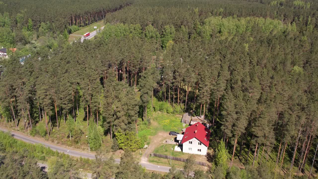 Aerial view of lush green forests with scattered houses and a highway
