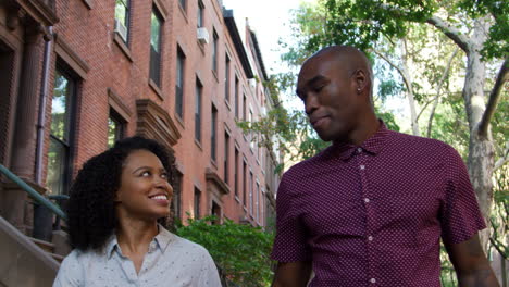 young couple walking along urban street in new york city