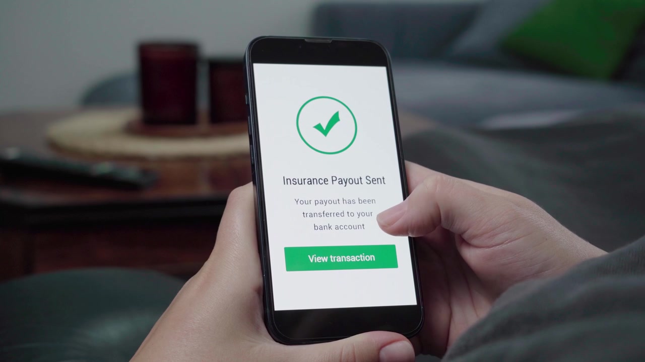 Un'app mobile mostra una conferma di avvenuto pagamento assicurativo mentre un utente si rilassa su un divano e si prepara a visualizzare la transazione.