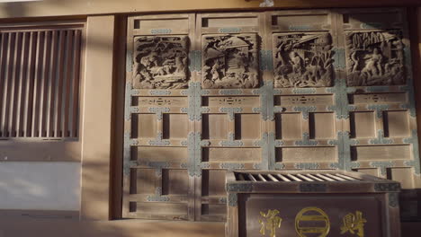 Hand-carvings-in-Japanese-temples-are-very-common,-in-this-case-in-the-central-building-of-a-temple-in-Tokyo,-each-door-has-a-different-carving-with-great-work-in-the-details