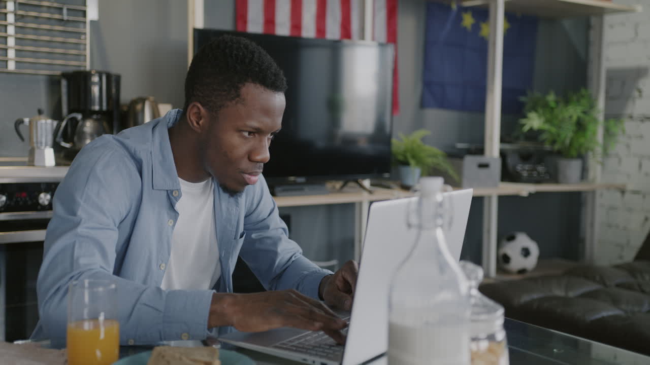 Man Working on Laptop in Kitchen