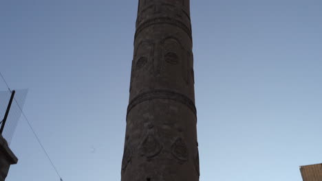 the camera scans the minaret of the historic mardin ulu mosque, made of cut stone, from the bottom up