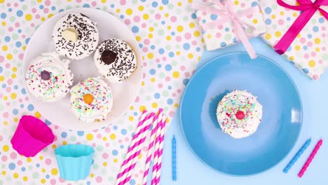 hand put cup cake on plate and birthday party decoration appear. stop motion