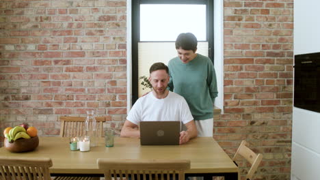 hombre trabajando en una computadora portátil en el comedor