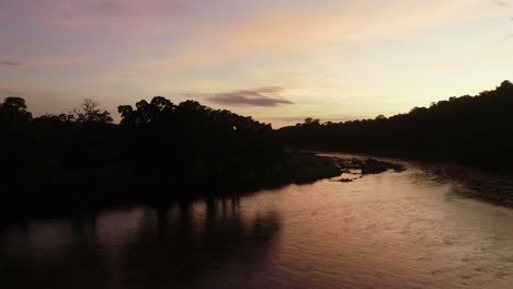 low flight over river reflecting pre-dawn golden sky, peaceful nature