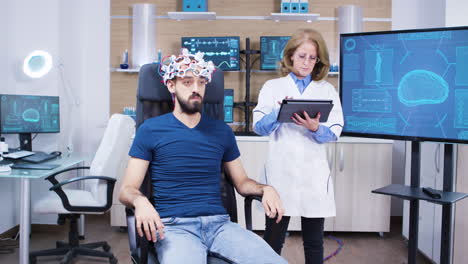 doctora chequeando la actividad cerebral del paciente masculino