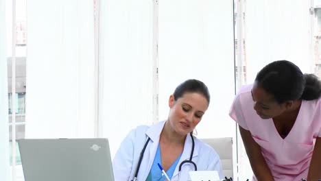 Pretty-female-doctors-talking-in-the-office-