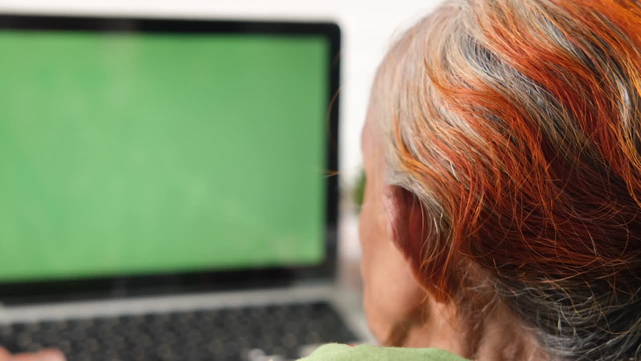 vista trasera de mujeres mayores usando una computadora portátil con pantalla en blanco