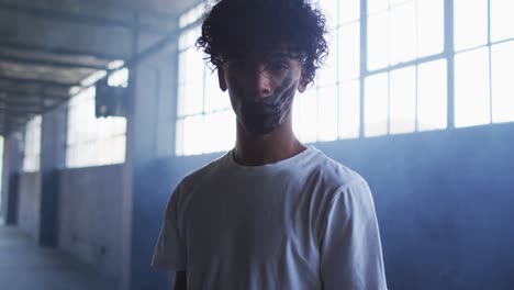 portrait of african american man with hand mark on their mouth standing in empty parking garage