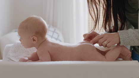 mother changing baby diaper at home caring for happy newborn infant loving mom cleaning childs nappy moisturizing skin enjoying motherhood childcare