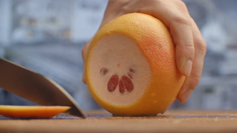 cortar pomelo en un tablero de madera de cerca. triturar.