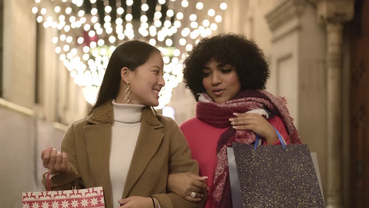 Two friends shopping at night during the holidays