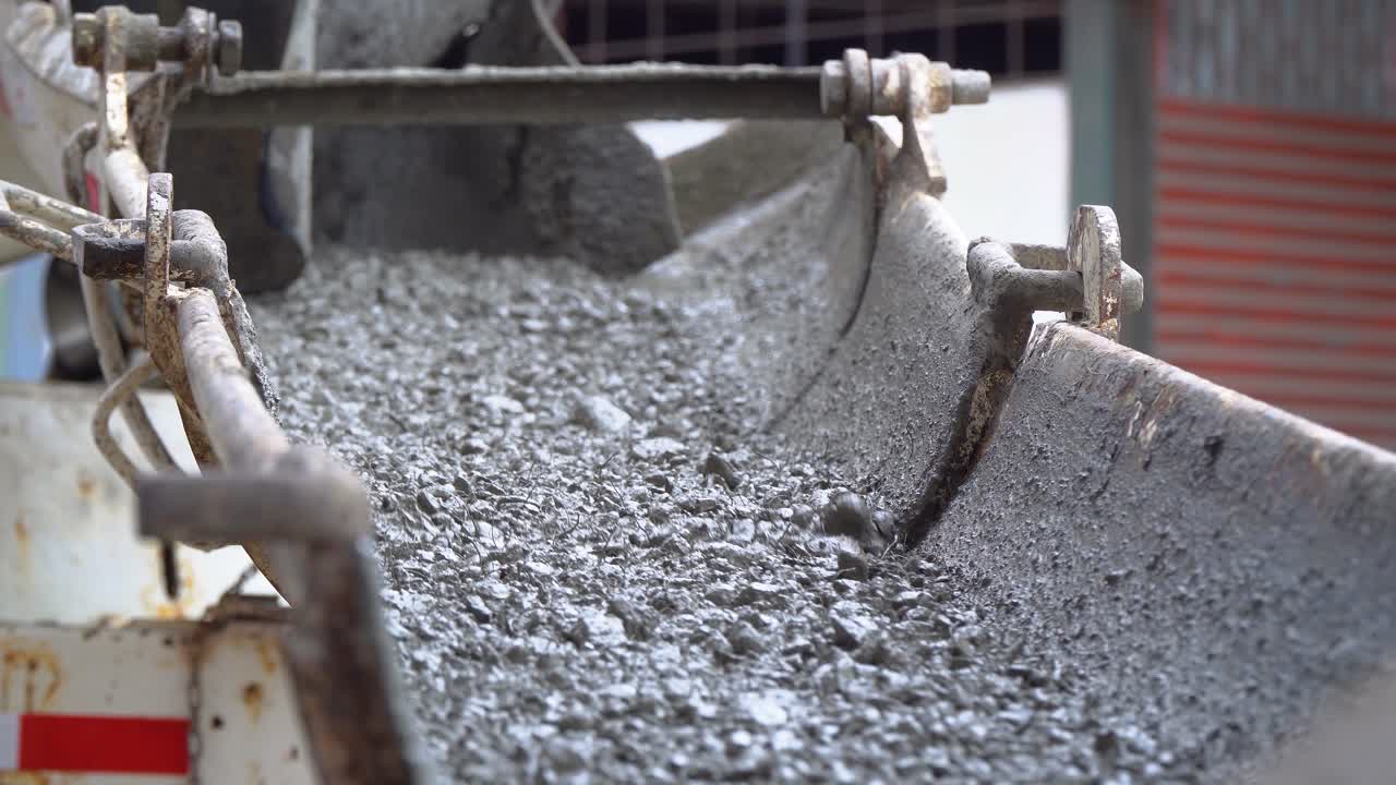 건설 현장의 컨베이어에서 컨테이너로 떨어지는 시멘트, 콘크리트 믹서 생산의 전망