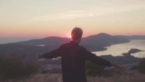 person enjoying sunset view from mountaintop