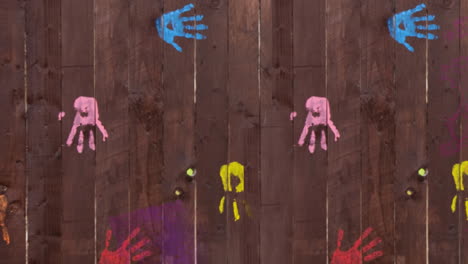 pink paint covering handprints on wooden boards