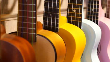 colorful ukuleles hanging in a row