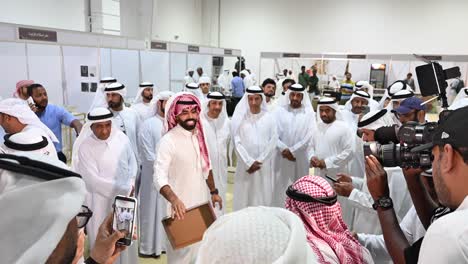 group of men in white dresses at an indoor event in the united arab emirates