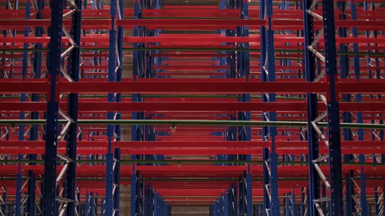 gran y moderno almacén en construcción, con estanterías metálicas y otros equipos industriales.