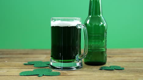 green pint of beer and bottle on table for st patrick