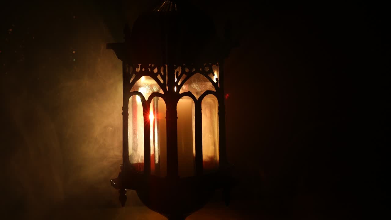 Arabic lantern with candle at night for Islamic holiday. Muslim holy month Ramadan. The end of Eid and Happy New Year. Copy space on dark background.
