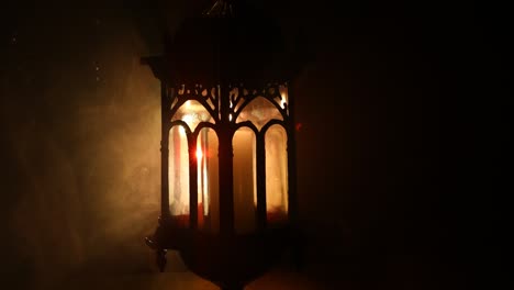 arabic lantern with candle at night for islamic holiday. muslim holy month ramadan. the end of eid and happy new year. copy space on dark background.