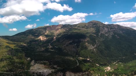 Aerial-Hyperlapse-Dolly-Out-Shot-über-Grünen-Hügeln-Mit-Sich-Bewegenden-Wolken,-Die-An-Einem-Bewölkten-Tag-Schatten-Auf-Die-Berge-Werfen