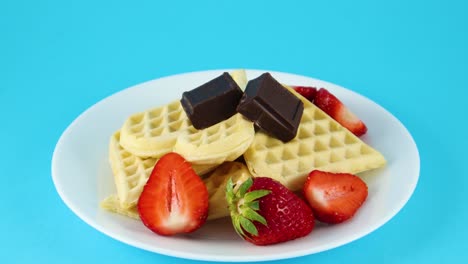 delicious waffles decorated with chocolate and strawberries on the plate