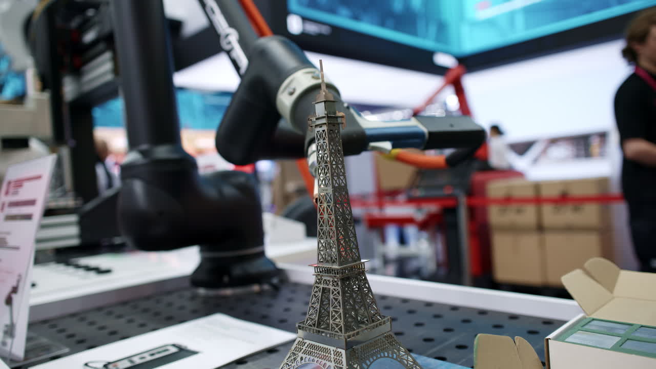 robot industrial y modelo de la torre eiffel en una exposición