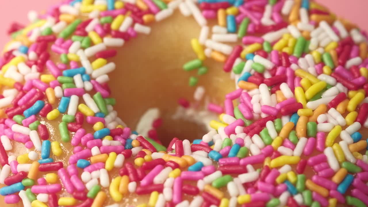 primer plano de una rosquilla cubierta de salpicaduras coloridas